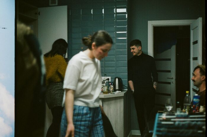 Group of people in a dimly lit room, capturing moments when people decided f***k this, I'm out and left abruptly.