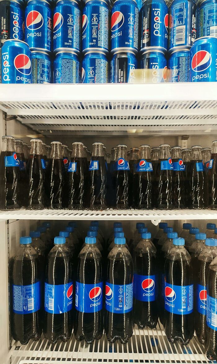 Rows of Pepsi bottles and cans stacked inside a refrigerator illustrating PR campaigns and decisions fails.