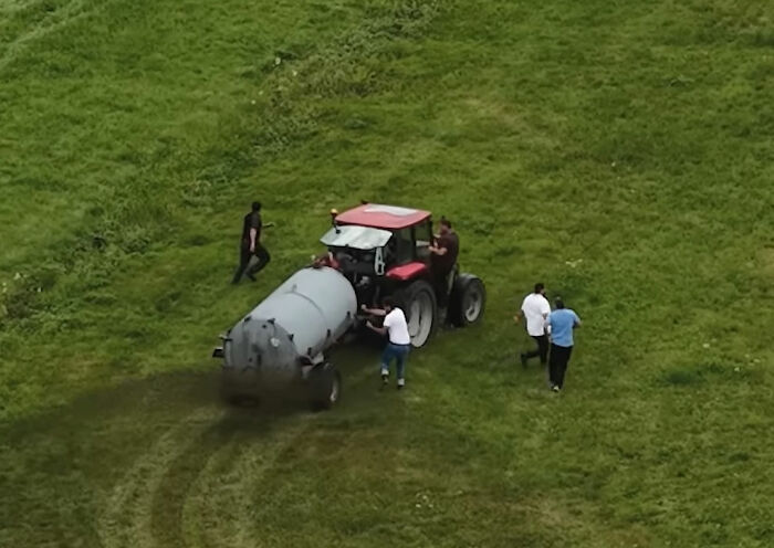 Farmer spraying manure from tractor on grassy field as people walk nearby in viral squatter incident captured by photographer Farmer spraying manure from tractor on grassy field as people walk nearby in viral squatter incident captured by photographer