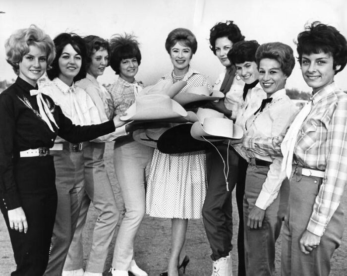LA women from 1962 posing together outdoors, dressed in vintage fashion with cowboy hats and smiling joyfully.