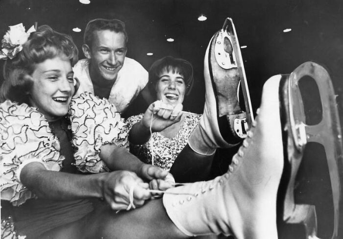 Three LA women in 1962 smiling and lacing up ice skates while living their best lives socially and actively.