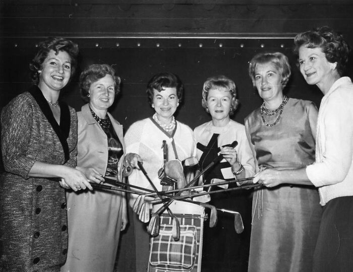 Group of LA women smiling and holding golf clubs, enjoying leisure activities in 1962.