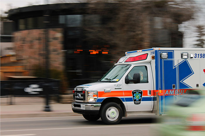 Ambulance speeding on city street, reflecting emergency response similar to police officers' crazy stories in real life.