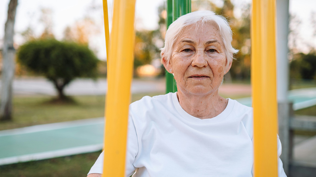 Elderly woman sitting outdoors, calm expression, representing memorable wild situations cops had to deal with.