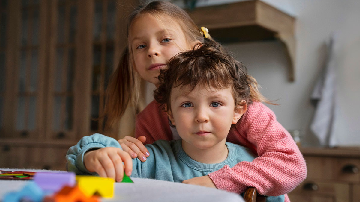 16YO twins looking serious indoors, one hugging the other, highlighting challenges of babysitting multiple younger kids.