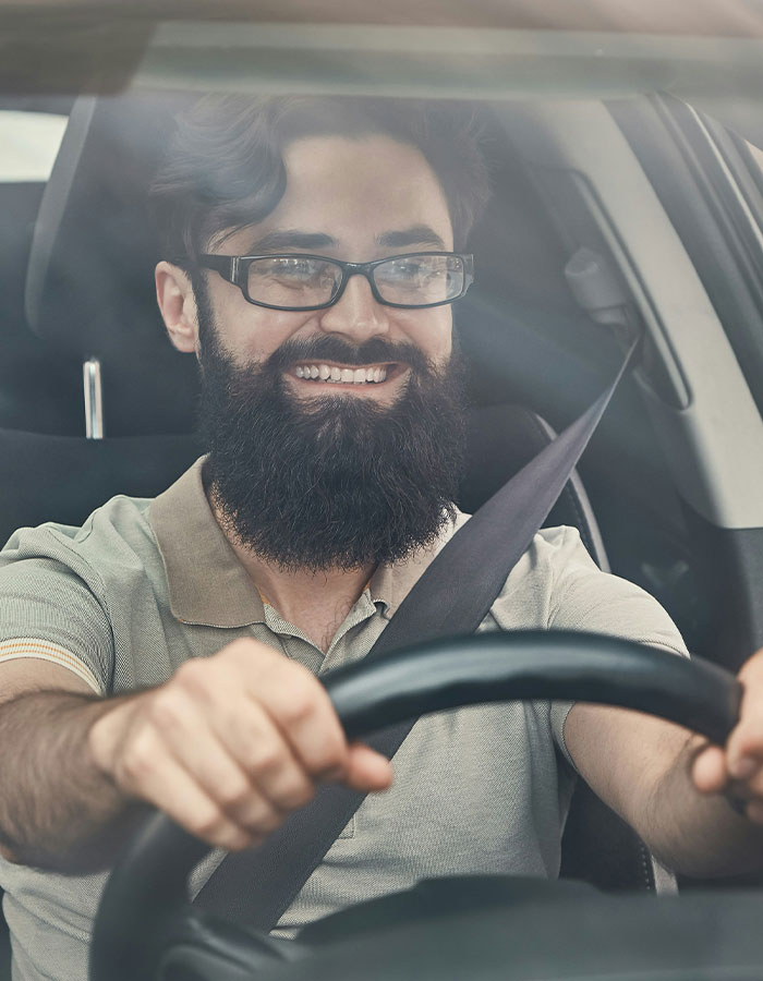 Bearded man smiling and driving a car, illustrating a road rage passenger's coffee toss backfiring hilariously. Bearded man smiling and driving a car, illustrating a road rage passenger's coffee toss backfiring hilariously.