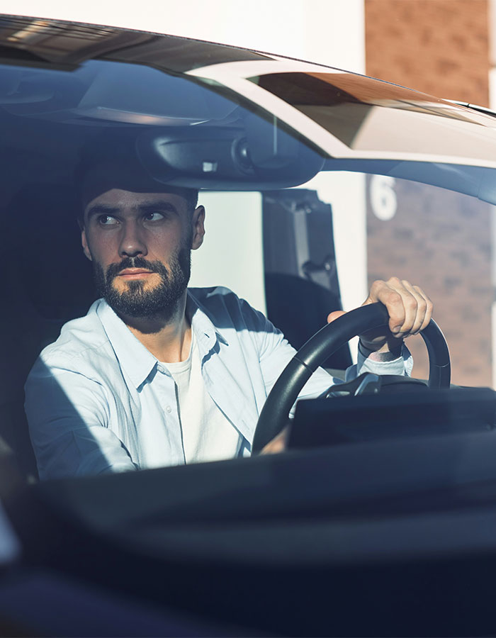 Man driving car with a serious expression, depicting road rage passenger coffee toss instant karma moment. Man driving car with a serious expression, depicting road rage passenger coffee toss instant karma moment.
