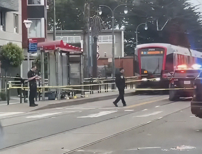 Police securing a transit area with tape near a stopped tram after a good Samaritan protects helpless mom and children. Police securing a transit area with tape near a stopped tram after a good Samaritan protects helpless mom and children.