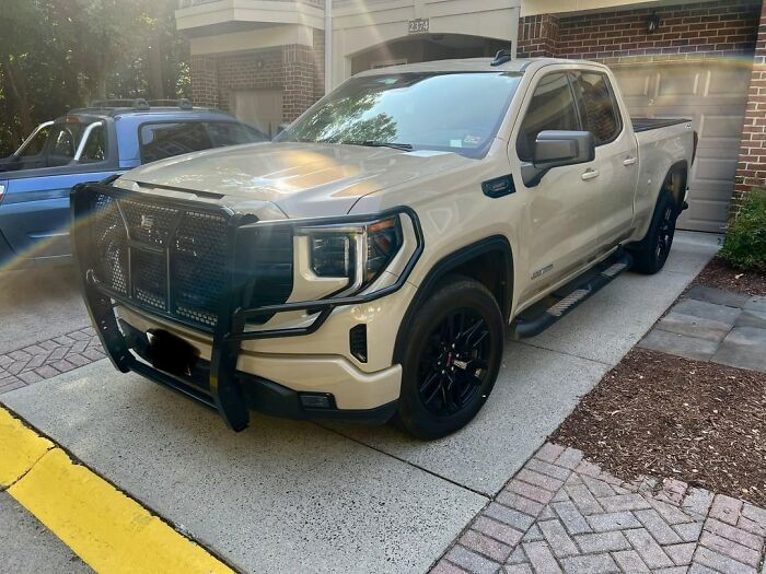 White pickup truck with aggressive front grille guard parked on driveway showing alpha vibe traits.