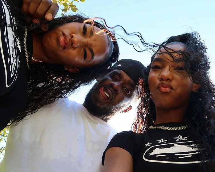 Sean Diddy Combs with his twin daughters outdoors, all making playful faces with wind blowing through their hair. Sean Diddy Combs with his twin daughters outdoors, all making playful faces with wind blowing through their hair.
