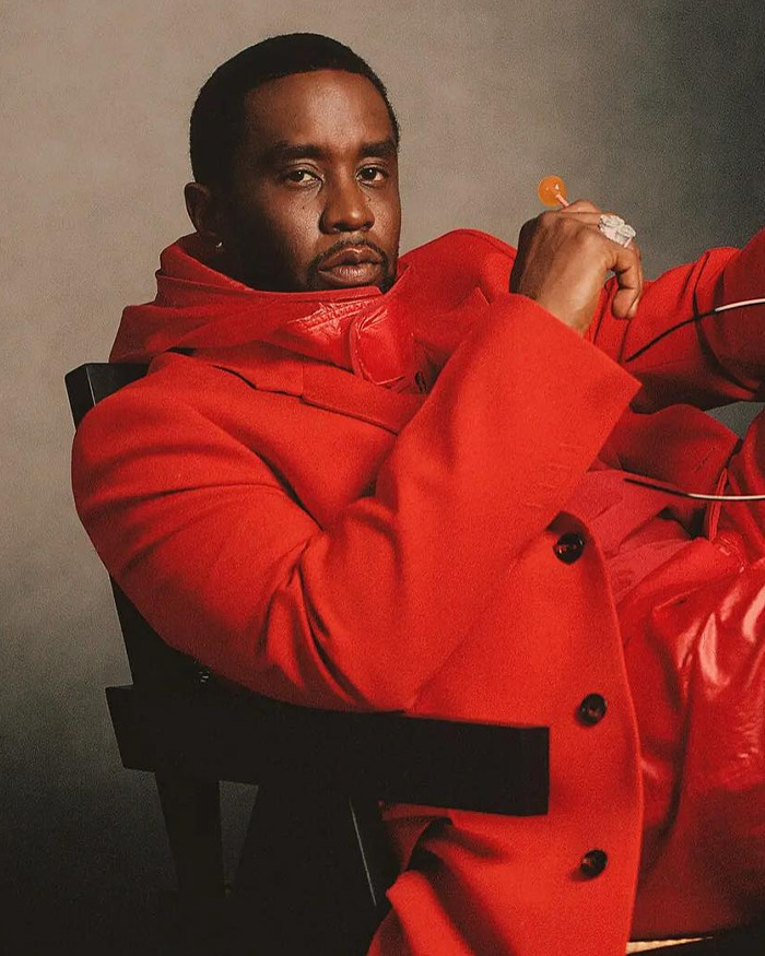 Sean Diddy Combs wearing a red coat, seated on a chair, looking at the camera with a serious expression. Sean Diddy Combs wearing a red coat, seated on a chair, looking at the camera with a serious expression.