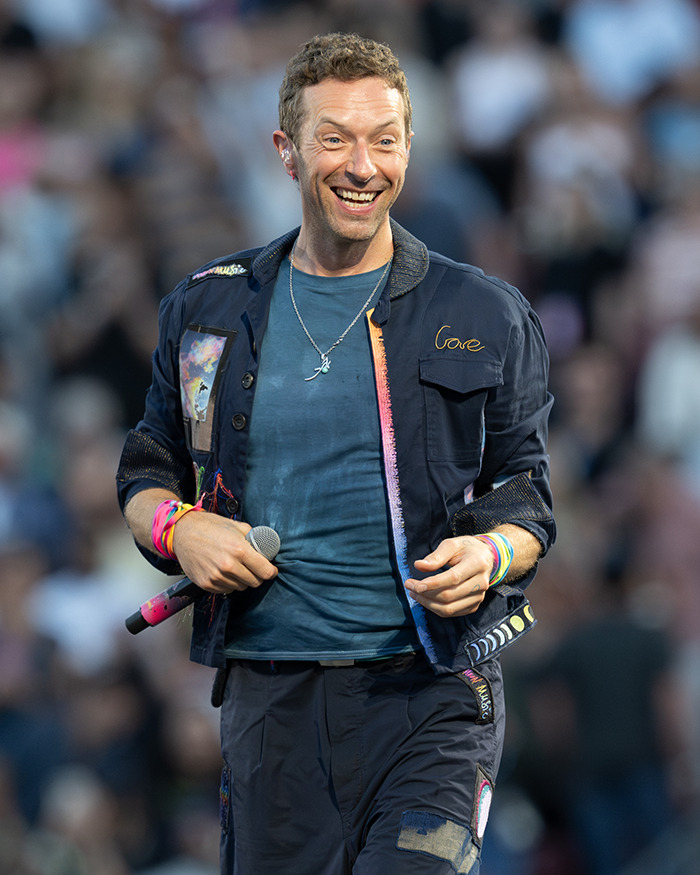 Chris Martin performing onstage, smiling and holding a microphone as fans speculate on Shakira and Chris Martin romance. Chris Martin performing onstage, smiling and holding a microphone as fans speculate on Shakira and Chris Martin romance.