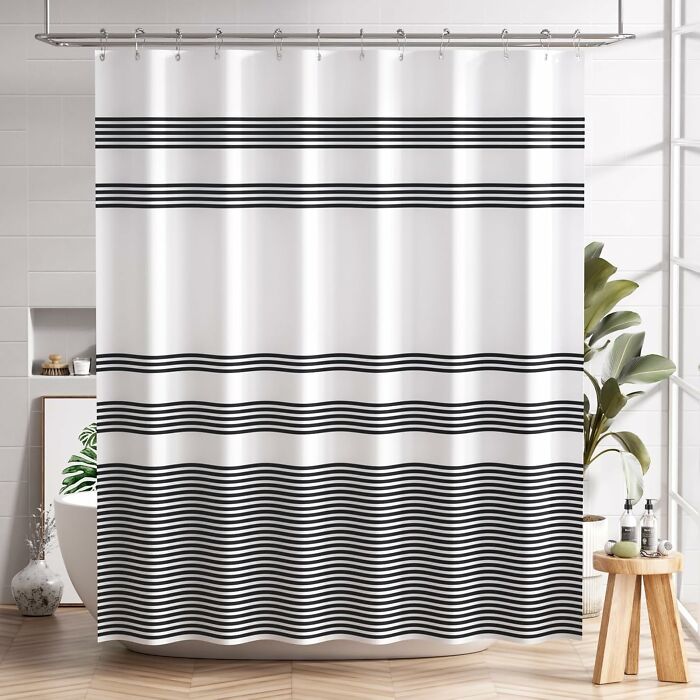 Modern bathroom with black and white striped shower curtain showcasing low-lift, high-impact improvements and design.