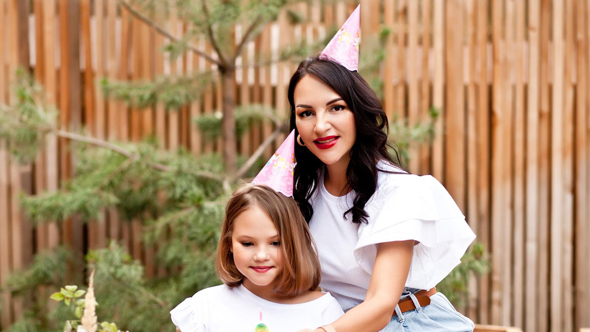 Woman celebrating niece's birthday wearing party hats, highlighting a niece's birthday and spiritual awakening theme.