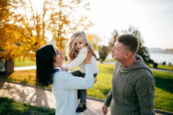 Family outdoors in autumn, parents interacting with their young daughter, highlighting adopted sis chosen one joke backfiring story. Family outdoors in autumn, parents interacting with their young daughter, highlighting adopted sis chosen one joke backfiring story.
