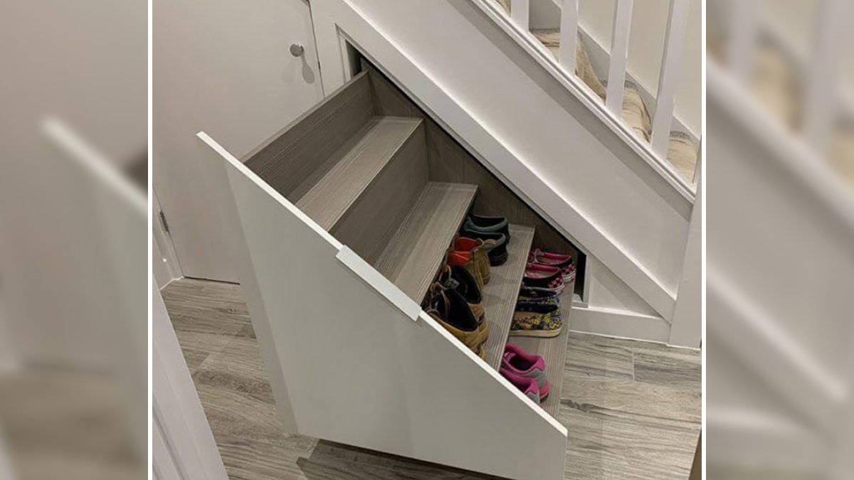 Under-stair storage designed as sliding shelves neatly holding multiple pairs of shoes in a compact real-world design.