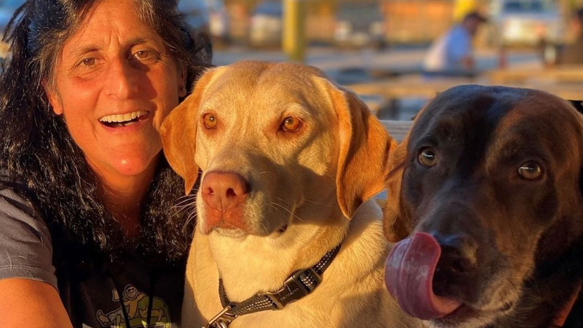 Astronaut joyfully reunited with her dogs after 10 months, capturing the best homecoming ever in a warm outdoor setting.