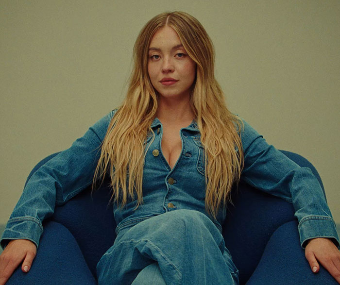 Sydney Sweeney seated in a denim outfit, breaking social media silence after Genes ad amid online trolling. Sydney Sweeney seated in a denim outfit, breaking social media silence after Genes ad amid online trolling.