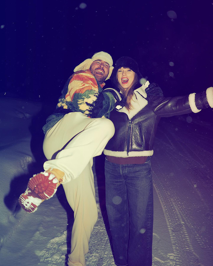 Travis Kelce and Taylor Swift outdoors at night in winter clothing, showing playful body language and joyful expressions. Travis Kelce and Taylor Swift outdoors at night in winter clothing, showing playful body language and joyful expressions.
