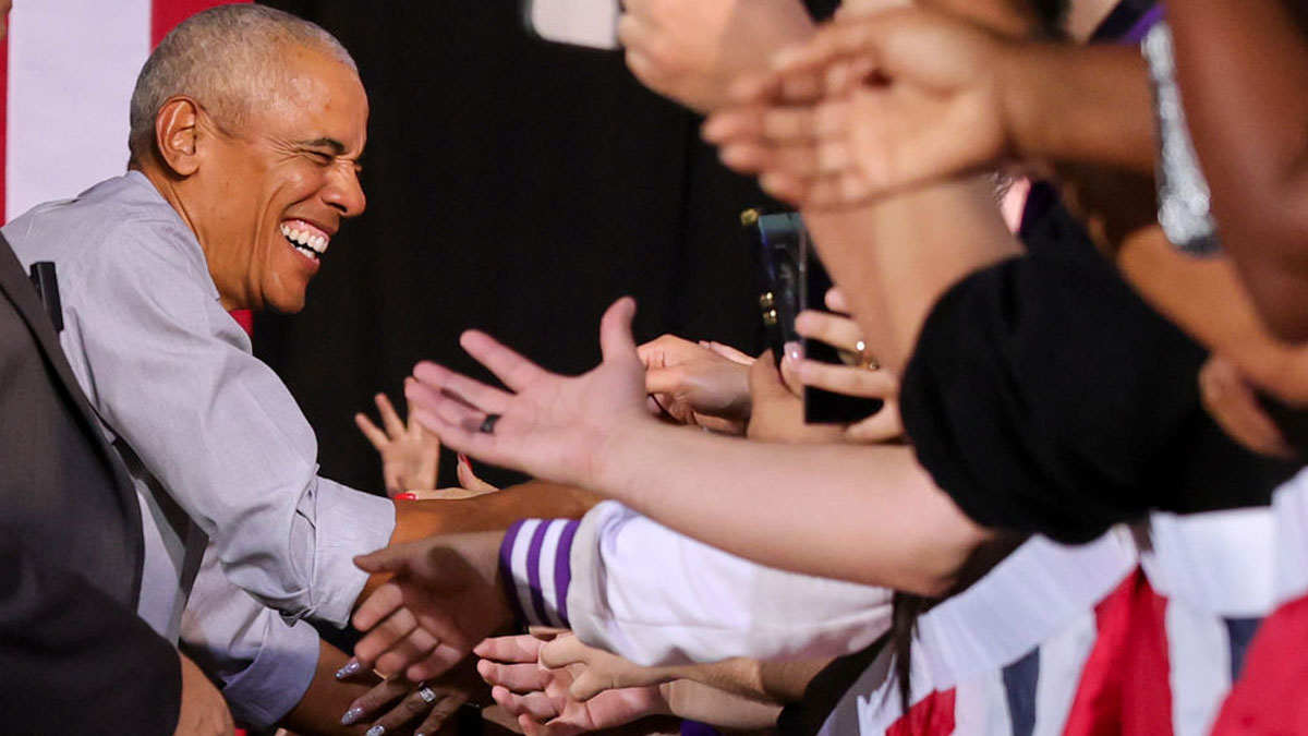 Barack Obama smiling and shaking hands with supporters reflecting his net worth growth and shift into global media.