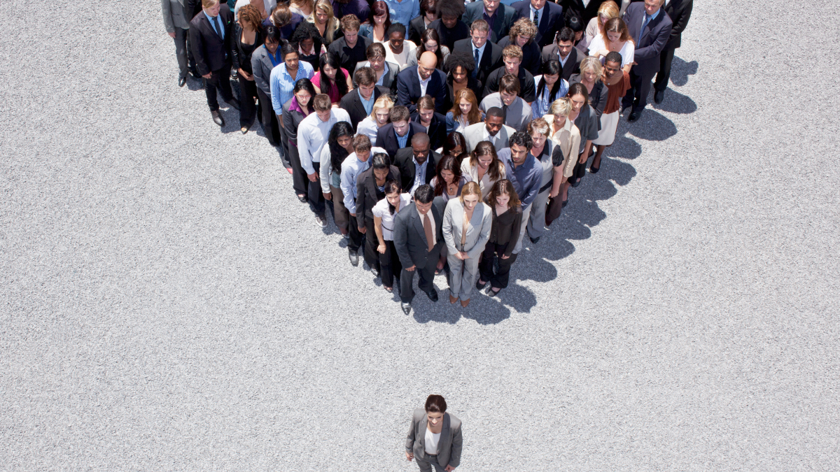 A group of diverse business people standing in a triangle formation highlighting Maslowu2019s hierarchy of needs concept.