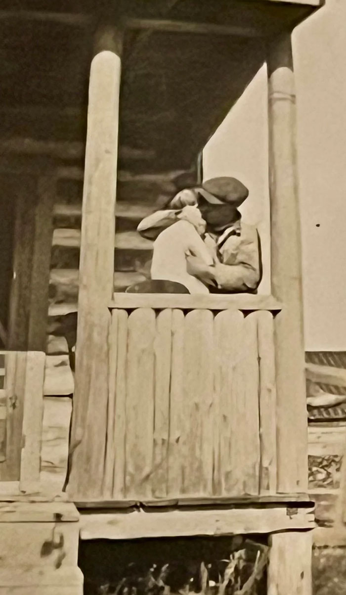 Couple sharing a tender moment on a rustic wooden porch in a candid glimpse into the past from vintage history photos.