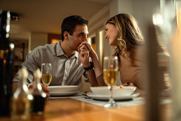Couple sharing a tender moment at dinner, evoking bittersweet childhood memories that felt sweet but became unsettling.