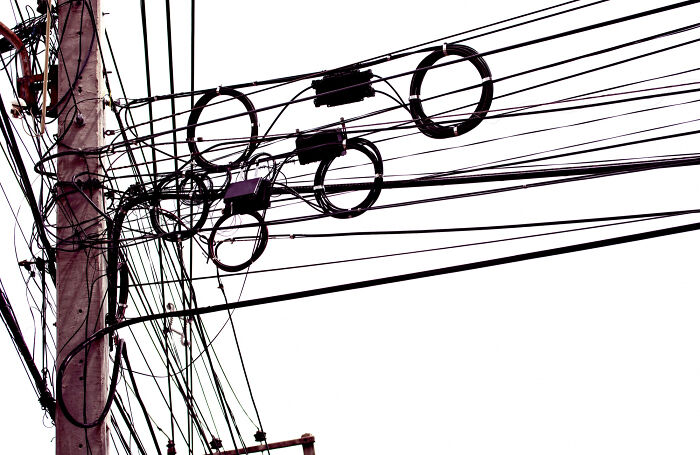 Tangled electrical wires on a utility pole evoking childhood memories that felt sweet but became unsettling in retrospect.