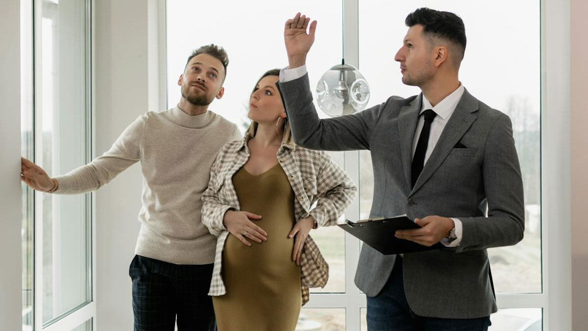 A psychic reading with a couple listening closely as the man in a suit makes predictions holding a clipboard indoors.