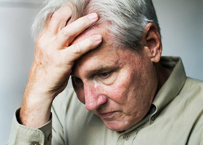 Older man looking distressed with hand on forehead, reflecting a dad’s reaction to dead grandchild news. Older man looking distressed with hand on forehead, reflecting a dad’s reaction to dead grandchild news.