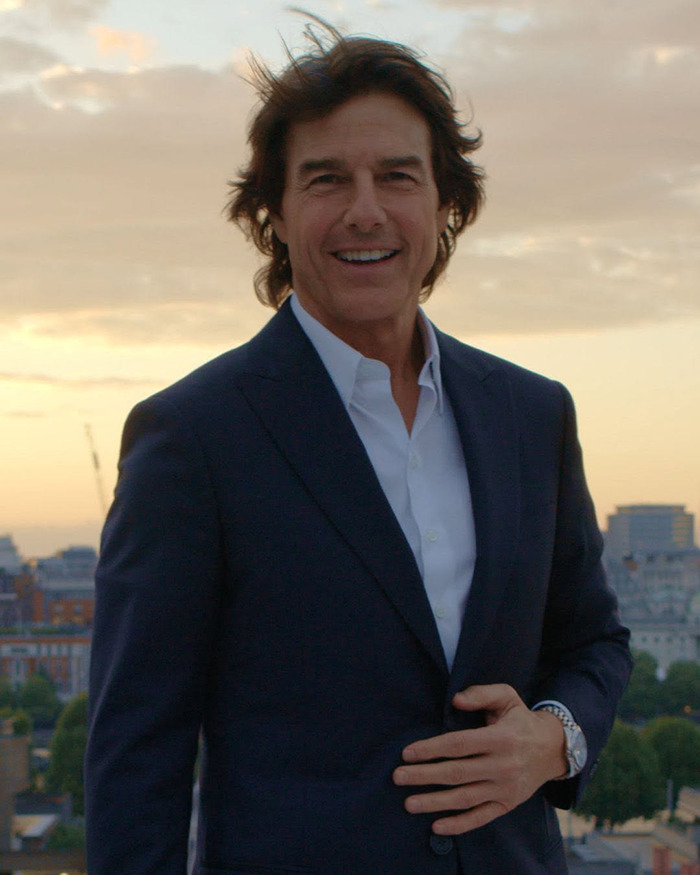 Tom Cruise smiling in a dark suit outdoors during sunset, related to candid photo with Ana de Armas going viral. Tom Cruise smiling in a dark suit outdoors during sunset, related to candid photo with Ana de Armas going viral.