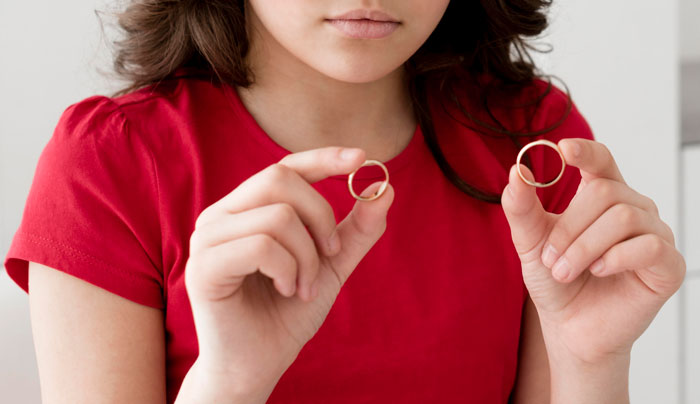 Young woman in a red shirt holding two gold rings, representing one of the most common tourist traps. Young woman in a red shirt holding two gold rings, representing one of the most common tourist traps.