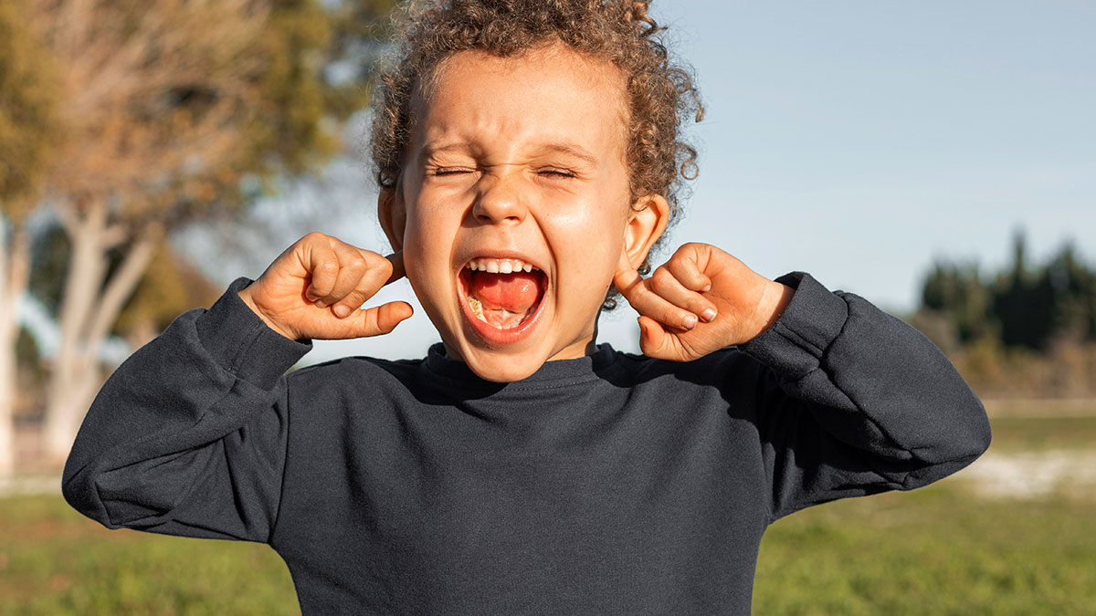 Child covers ears and screams outdoors, illustrating challenges of woman keeping promise to train cousinu2019s kids after babysitting.
