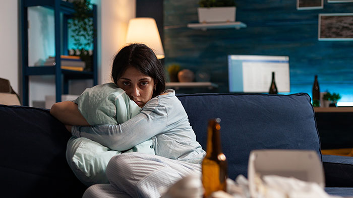 Young woman looking confused and upset on a couch after boyfriend’s sister starts hitting on her in a tense living room. Young woman looking confused and upset on a couch after boyfriend’s sister starts hitting on her in a tense living room.