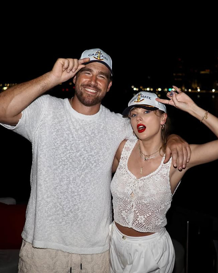 Travis Kelce’s ex and Taylor Swift posing together at night wearing matching captain and mate hats. Travis Kelce’s ex and Taylor Swift posing together at night wearing matching captain and mate hats.
