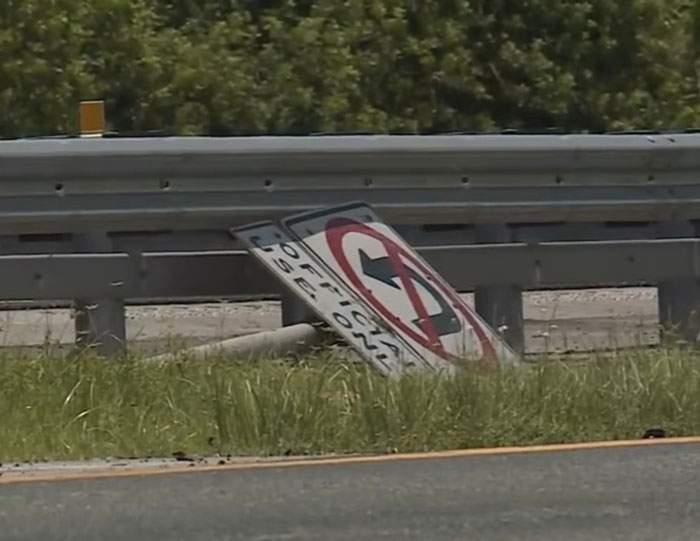 Fallen no U-turn traffic sign next to highway guardrail, relating to illegal U-turn and truck driver crash incident. Fallen no U-turn traffic sign next to highway guardrail, relating to illegal U-turn and truck driver crash incident.