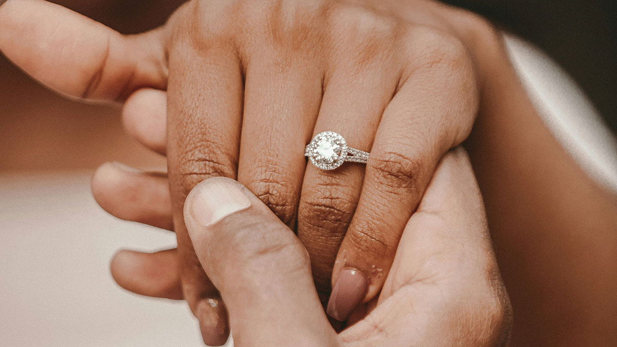 Close-up of hands with an engagement ring, symbolizing unhinged MILs comments about relationships and marriage.