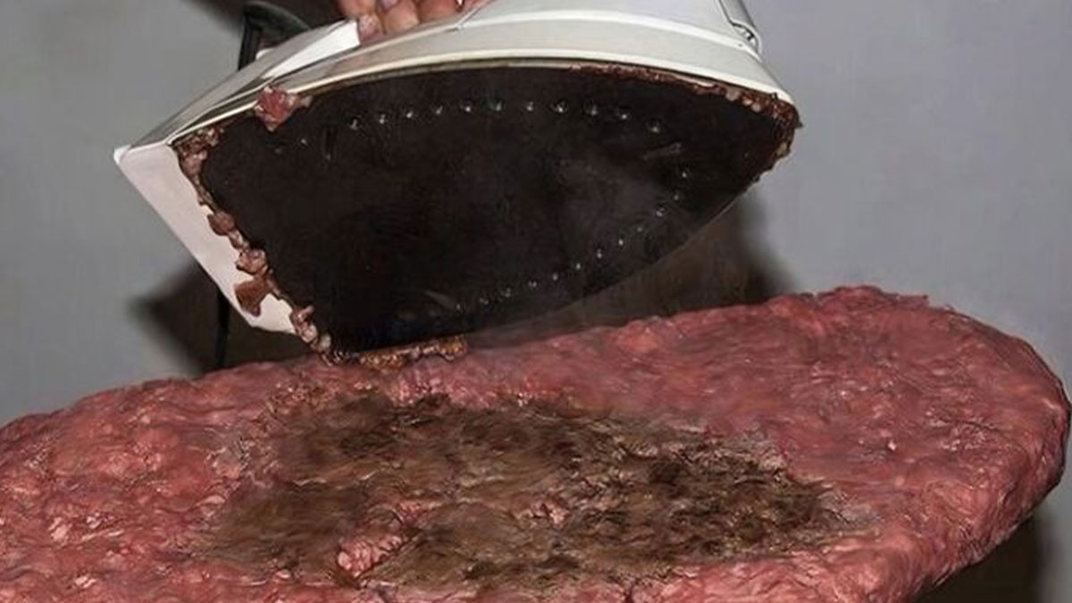 Iron pressing a raw, unhealthy-looking meat patty, illustrating food nobody should eat for health.