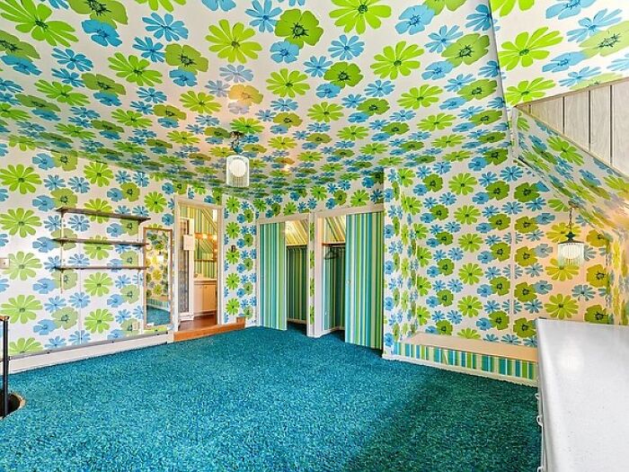 Vintage closet room with bright floral wallpaper and blue carpet reflecting June Cleavers vintage closet style.