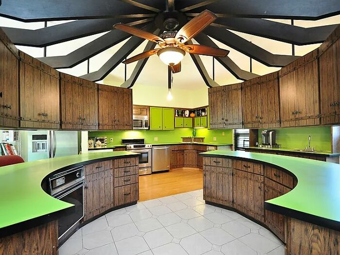 Vintage kitchen with curved wooden cabinets and lime green countertops, evoking June Cleavers vintage closet style.