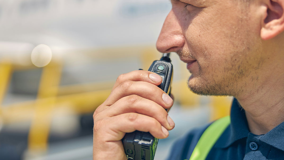 Close-up of Walmart employee using walkie talkie in outdoor work setting, capturing wild times at work moments.