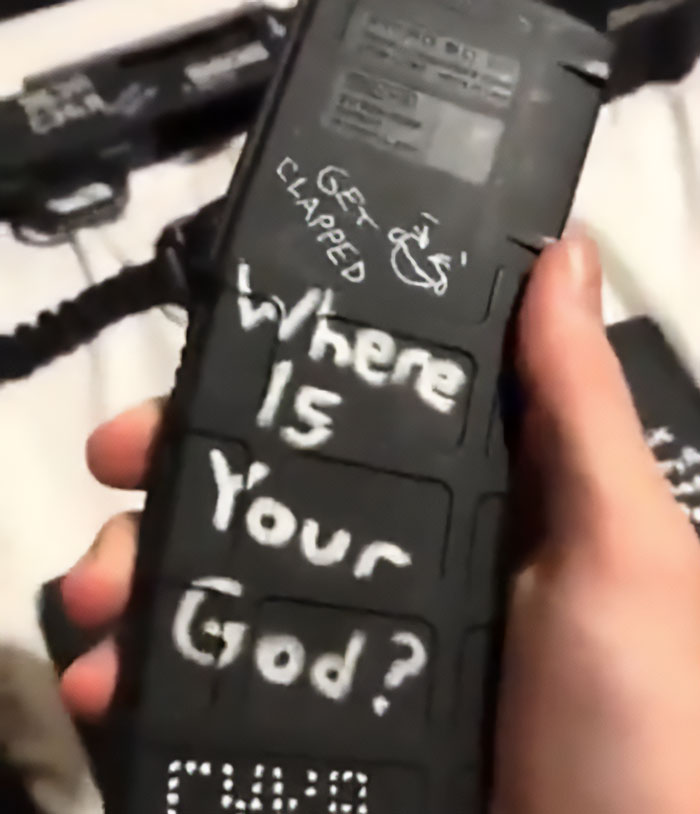 Hand holding a black magazine with disturbing white text written on it related to Minneapolis massacre culprit manifesto. Hand holding a black magazine with disturbing white text written on it related to Minneapolis massacre culprit manifesto.