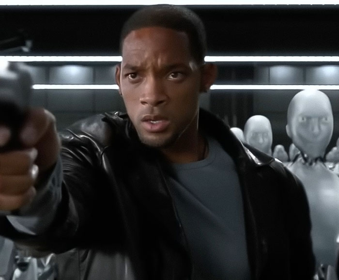 Will Smith aiming a gun in a scene with robots in the background, related to co-actor publicity removal claim. Will Smith aiming a gun in a scene with robots in the background, related to co-actor publicity removal claim.