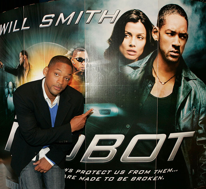Will Smith posing next to a Robo movie poster, related to co-actor accusing studio of name removal claim. Will Smith posing next to a Robo movie poster, related to co-actor accusing studio of name removal claim.