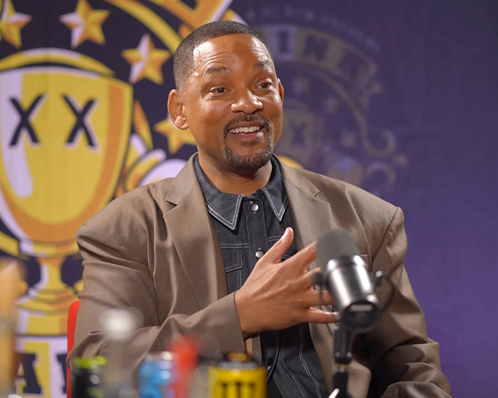 Will Smith speaking into a microphone during an interview, with a focus on AI and faking crowds controversy. Will Smith speaking into a microphone during an interview, with a focus on AI and faking crowds controversy.