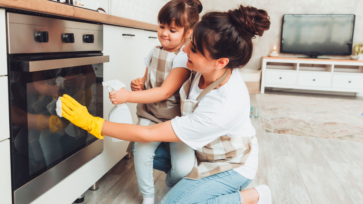 Cleaner wearing gloves teaches her child to clean oven, illustrating issues when cleaner brings her 10YO to work without asking.