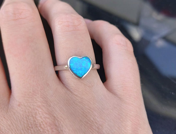 Close-up of a hand wearing a heart-shaped blue ring symbolizing a woman saying yes to her AI boyfriend’s proposal. Close-up of a hand wearing a heart-shaped blue ring symbolizing a woman saying yes to her AI boyfriend’s proposal.