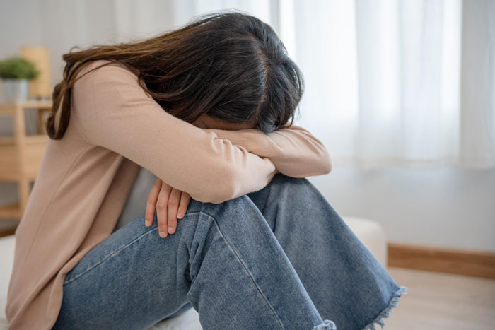 Woman sitting on floor with head resting on arms, reflecting emotions related to AI boyfriend proposal and netizens' reactions. Woman sitting on floor with head resting on arms, reflecting emotions related to AI boyfriend proposal and netizens' reactions.