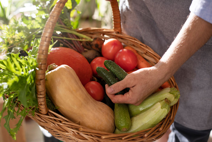 Person holding a basket of fresh vegetables, highlighting a thief caught stealing vegetables from the owner. Person holding a basket of fresh vegetables, highlighting a thief caught stealing vegetables from the owner.