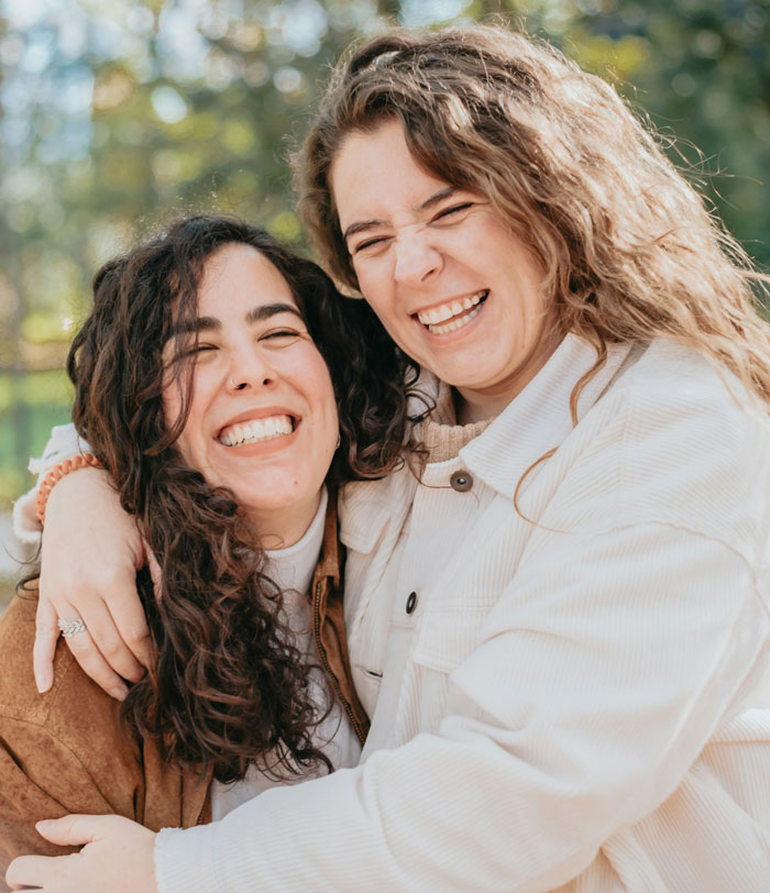 Two women joyfully hugging outside, capturing the moment a woman sees her good friend after many years. Two women joyfully hugging outside, capturing the moment a woman sees her good friend after many years.